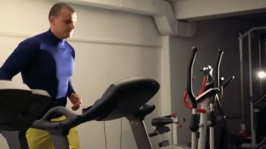 Modern spor salonunda 4 k yarış pisti ile egzersiz yapan erkek