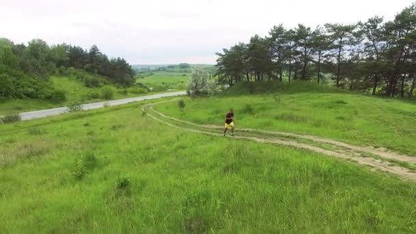 Vista aérea del hombre corriendo cruz en el camino 4k — Vídeos de Stock