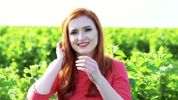 Retrato de menina feliz sorrindo e tocando o cabelo n o campo de trigo verde. Devagar. — Vídeo de Stock