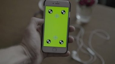Smartphone ile yeşil ekran tutan adam kapatın