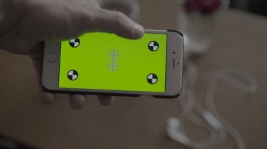 Smartphone ile yeşil ekran tutan adam kapatın