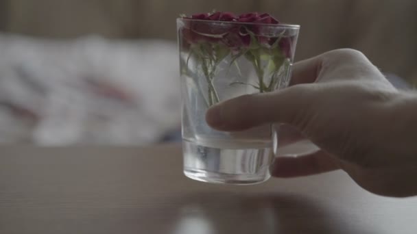 Стекло с розами на столе — стоковое видео