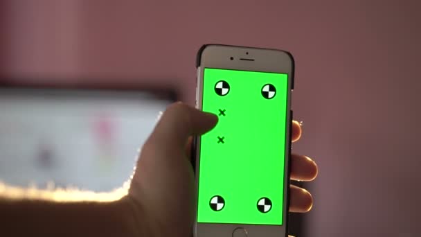 緑の画面でスマートフォンのタッチスクリーンを保持している男を閉じるクロマキー — ストック動画
