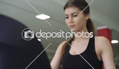 Bir koşu bandı üzerinde güzel bir kız. 4k