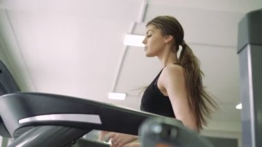 Bir koşu bandı üzerinde güzel bir kız. 4k