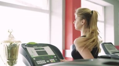 Güzel sarışın spor salonunda treadmill. 4k