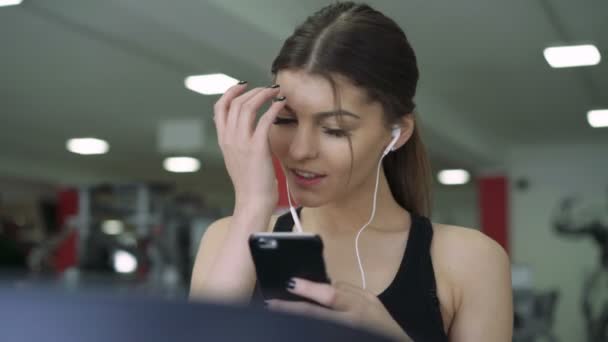 Close-up of a girl with headphones on a treadmill. 4k — Stock Video