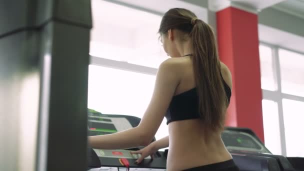 Hermosa chica en una cinta de correr. 4k — Vídeo de stock