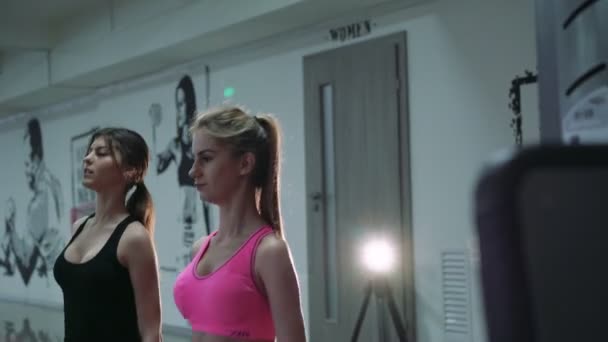 Две красивые девушки в штанах в спортзале. 4k — стоковое видео