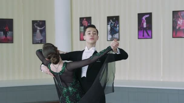 Jeune couple dansant des danses de salon dans le style classique. Mouvement lent — Video