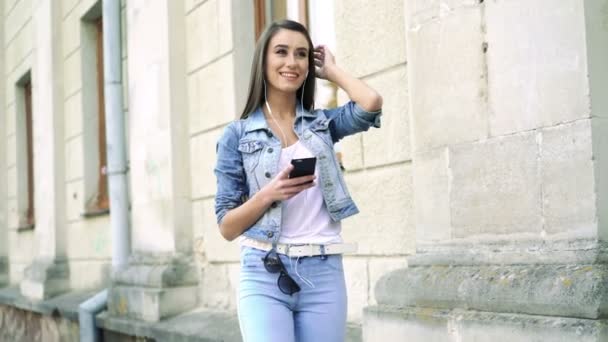 Mode Mädchen hören Musik am Telefon auf der Straße, indem sie Hintergrund. 4k — Stockvideo
