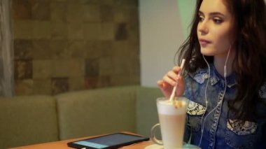 Güzel kız bir kafede müzik dinler