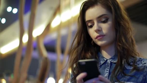 Hermosa chica escucha música en un café — Vídeo de stock