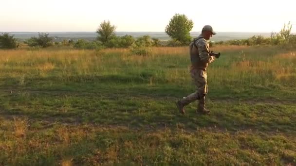 Vista aerea: guerriero armato va rapidamente sul campo al tramonto — Video Stock