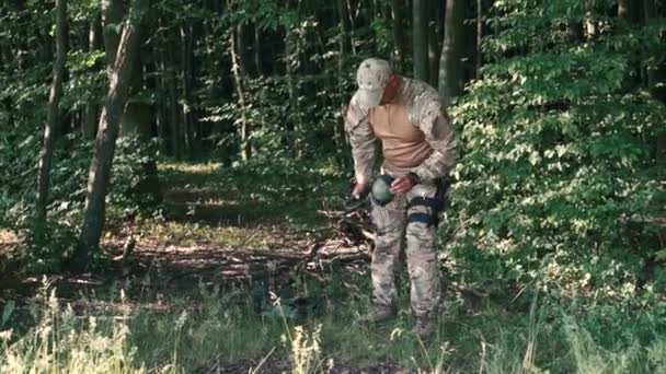 Military boy wears kneecap in the forest — Stock Video