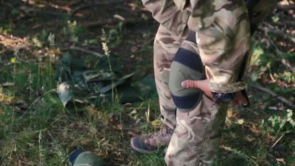 Nær militær mann bærer en kneskål i skogen – stockvideo