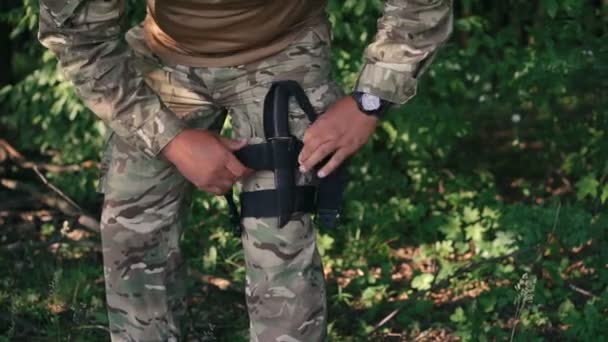 Soldier put on fastener for knife in the wood — Stock Video