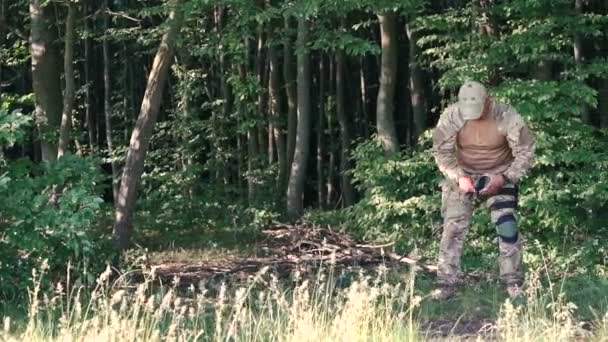 Militare uomo indossa rotula nella foresta — Video Stock