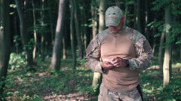 Militär schärft Messer mit Meilenstein im Wald — Stockvideo