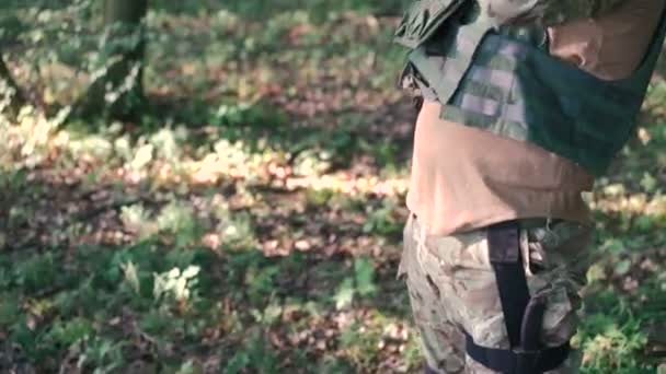 Закрытие воина надевает автомат в лесу — стоковое видео