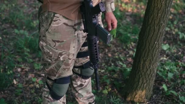 Крупним планом автоматизація на солдата в лісі — стокове відео
