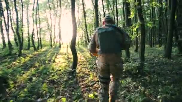 Вооруженные молодые военные бегут в лесу — стоковое видео