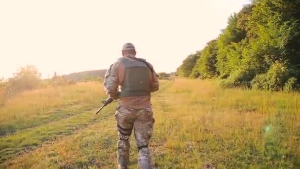 Militär med automat kör i fälten — Stockvideo