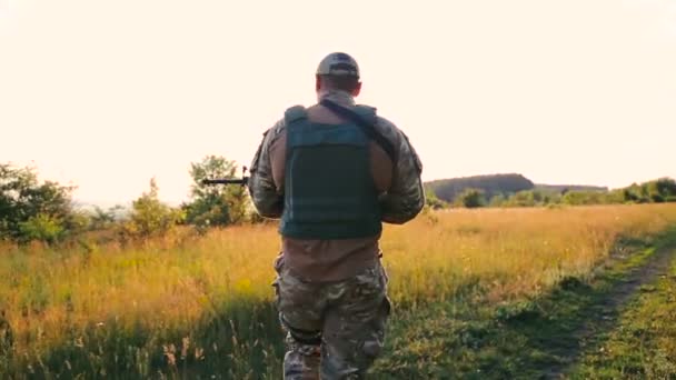 Primo piano di militari spalla con automa va nei campi — Video Stock