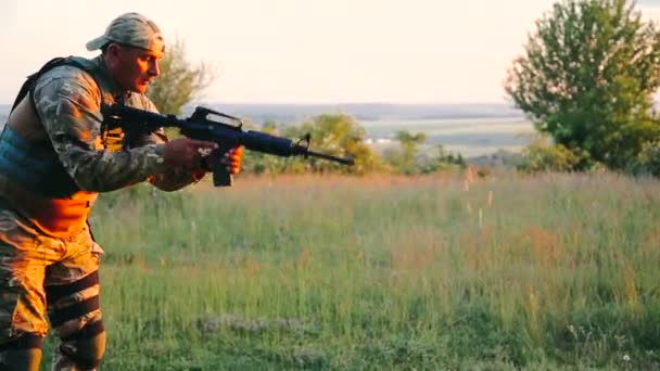 Military aims on the enemy with automaton in the steppe — Stock Video