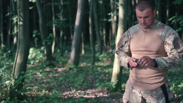 Couteau militaire aiguisé avec bilestone dans la forêt. Mouvement lent — Video