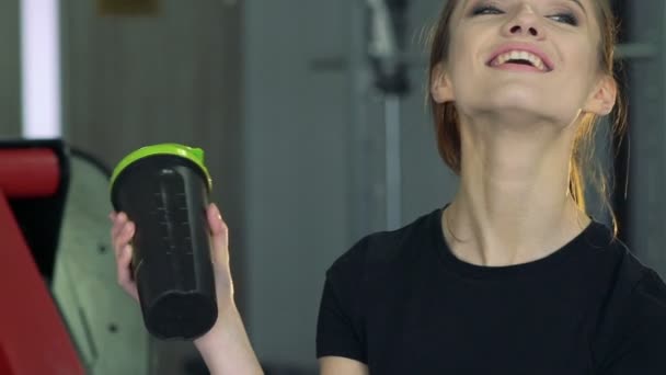 Schöne Mädchen mit einem Shaker in der Turnhalle — Stockvideo