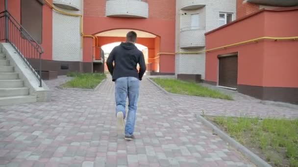 Young man running near the building — Stock Video