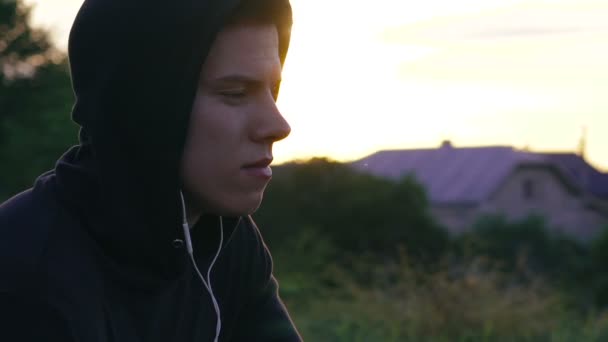 Χαρούμενος νεαρός άνδρας που ακούτε τη μουσική στα ακουστικά σχετικά με τη φύση — Αρχείο Βίντεο