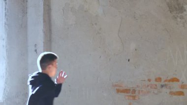 Bir duvardan bir genç adam geri çevirir. Yavaş yavaş