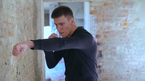 Тіньовий бокс Kickboxer як вправи для великої боротьби в старій будівлі. Повільно — стокове відео