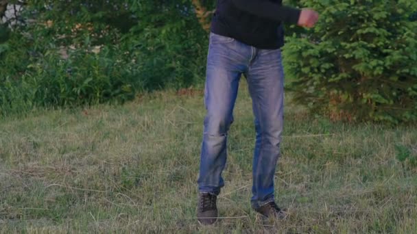 Un jeune homme qui s'entraîne au parkour saute dans le parc. Doucement. — Video