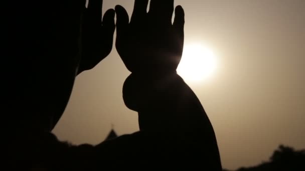 Hombre manos arriba al sol sobre fondo oscuro — Vídeos de Stock