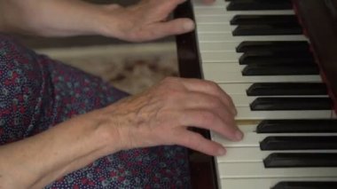 Buruşuk elleriyle yaşlı kadın piyano çalma
