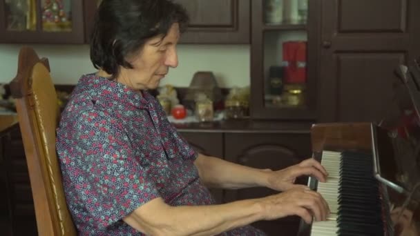 老女人是弹钢琴和看的照相机上 — 图库视频影像