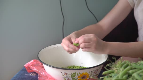 Young hands shelling green peas in the village — Stock Video