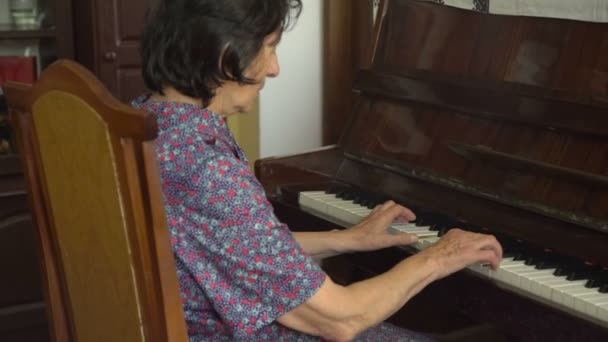 Viejo feliz abuela está tocando el piano — Vídeo de stock