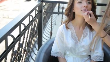 Genç güzel brideon için ruj kalem uygulayarak bir balkon - makyaj