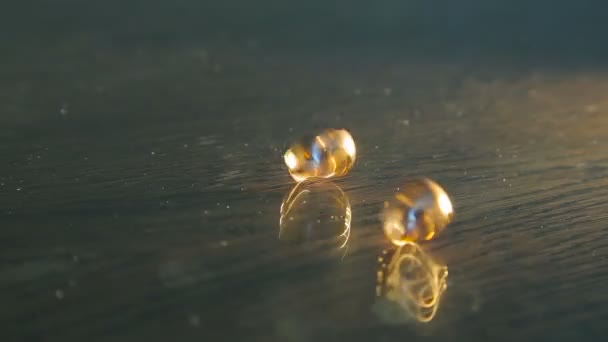 Gouden trouwringen cirkelen op tafel — Stockvideo