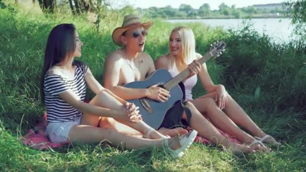 Trois amis reposant sur la nature et chantant. 4k — Video