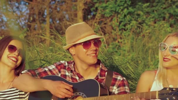 Amigos felizes tocando guitarra e sorrindo. Devagar. — Vídeo de Stock