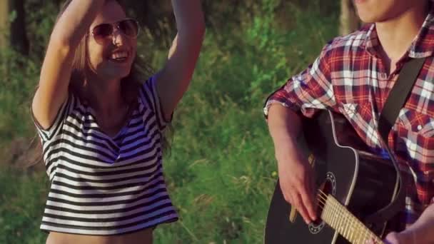 Hübsche Mädchen tanzen zu Gitarrenklängen im Park. langsam — Stockvideo