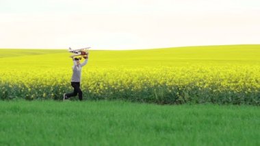 Mutlu çocuk oyuncak uçak tecavüz field yakınındaki ile çalışan. Ağır çekim