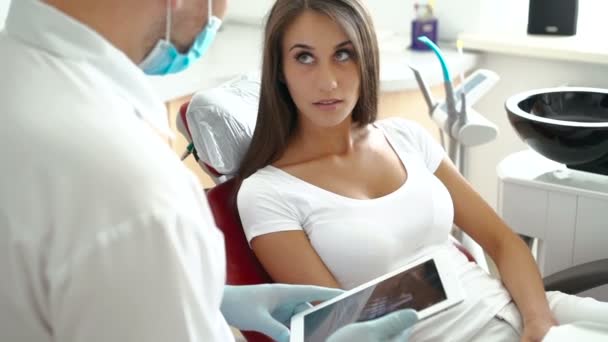 Dentist talking with woman using xray of teeth — Stock Video