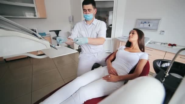 Dentista examinando los dientes de las mujeres jóvenes — Vídeo de stock