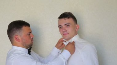 Bir arkadaş bir kravat giymeyi genç bir gelin yardımcı olur.